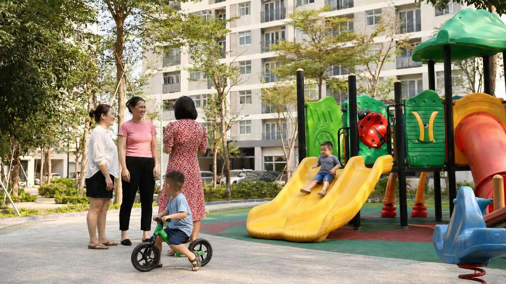Các bà mẹ trò chuyện thân thiện trong khi con vui chơi ở sân chơi.