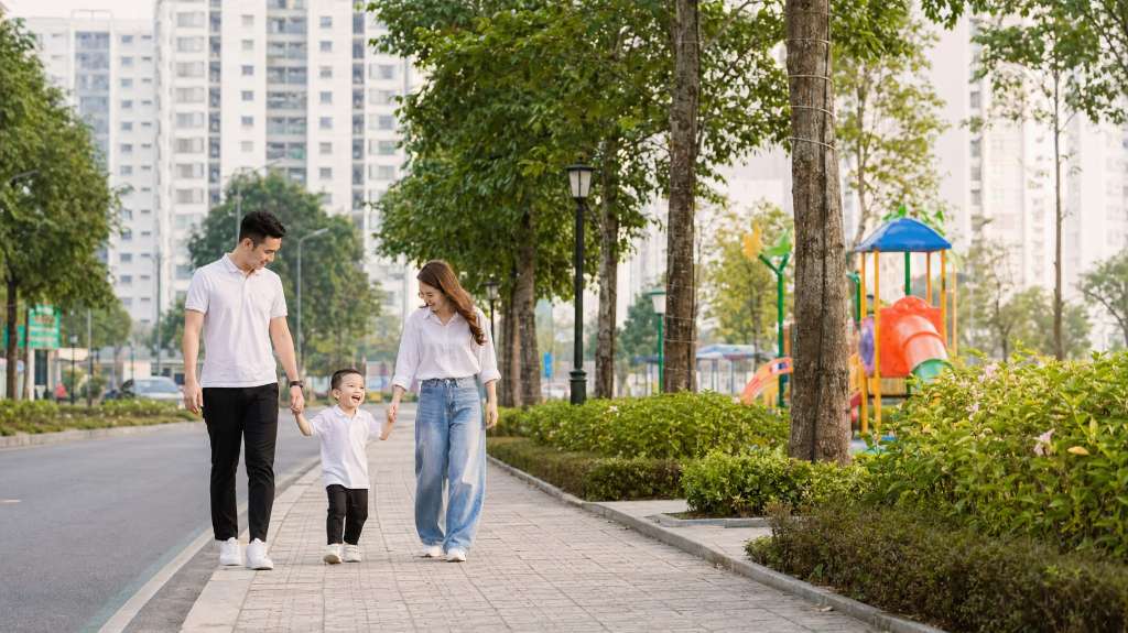 Gia đình trẻ dạo bộ vui vẻ trong khu đô thị xanh