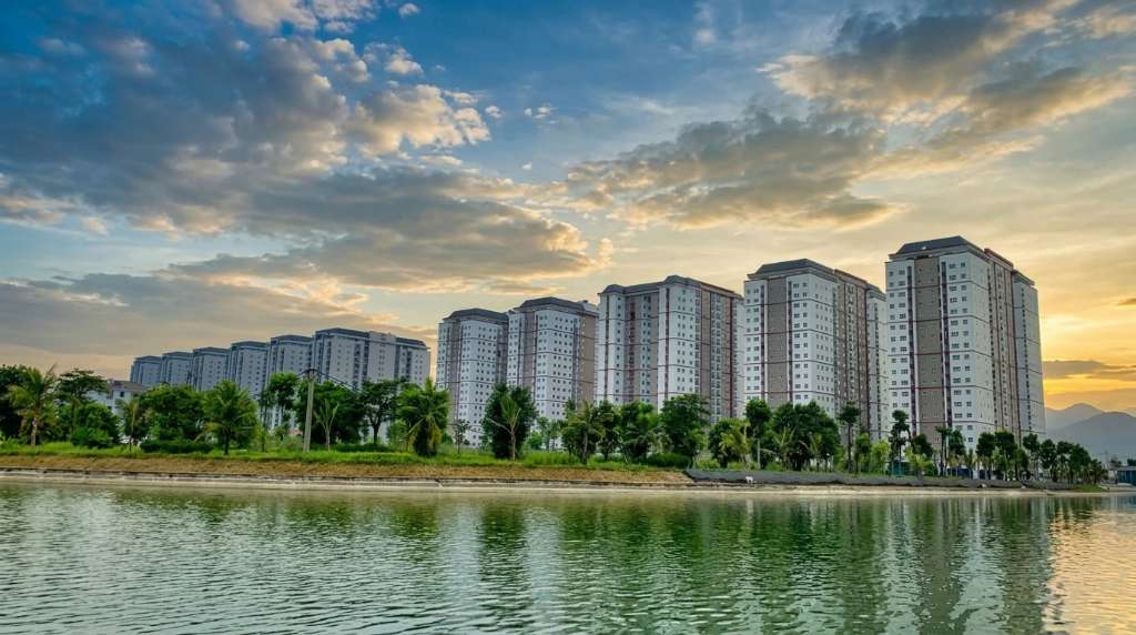 Người phụ nữ Việt Nam trẻ lái ô tô trên đường cao tốc đô thị buổi sáng, kính xe phản chiếu hàng cây xanh hai bên đường, gương mặt thoải mái tự tin, nội thất xe sạch sẽ, ánh sáng tự nhiên dịu nhẹ qua cửa kính, phong cách lifestyle photography, 4K