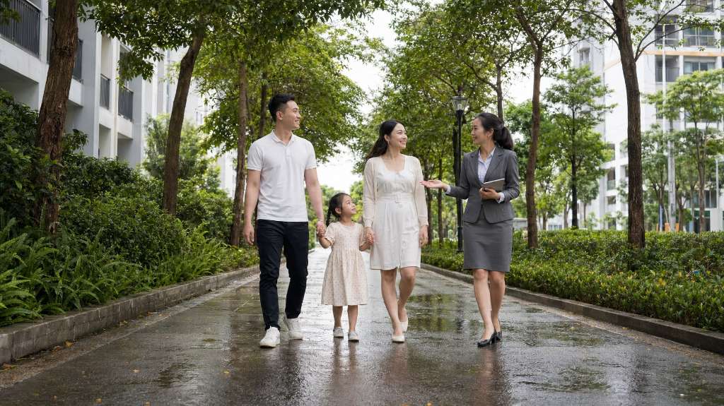 Gia đình trẻ dạo bước trong khuôn viên xanh mát cùng nhân viên tư vấn